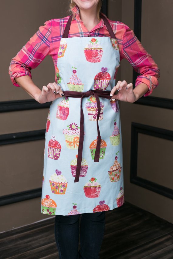 Blue cupcake print cotton apron, flat lay with contrasting straps