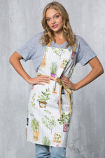 White herb pots print cotton apron with contrasting straps, front view