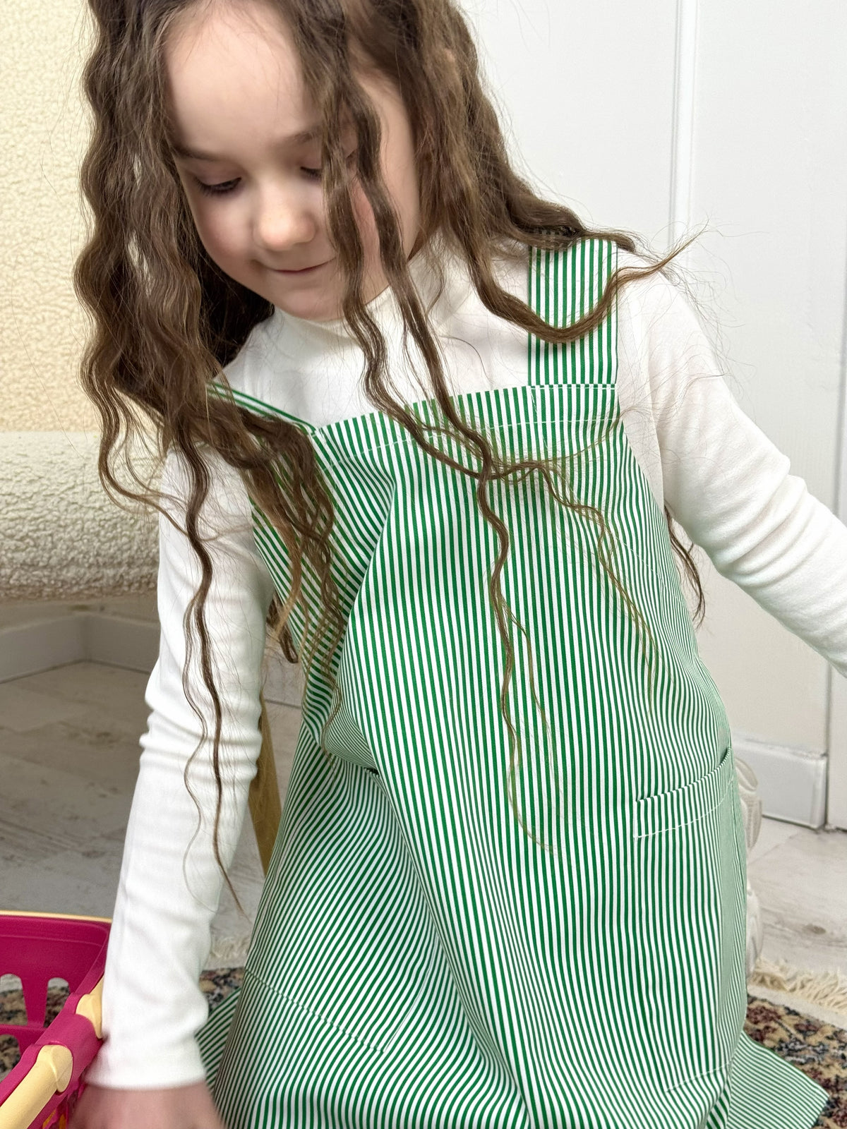 Kids craft apron in green stripe, styled