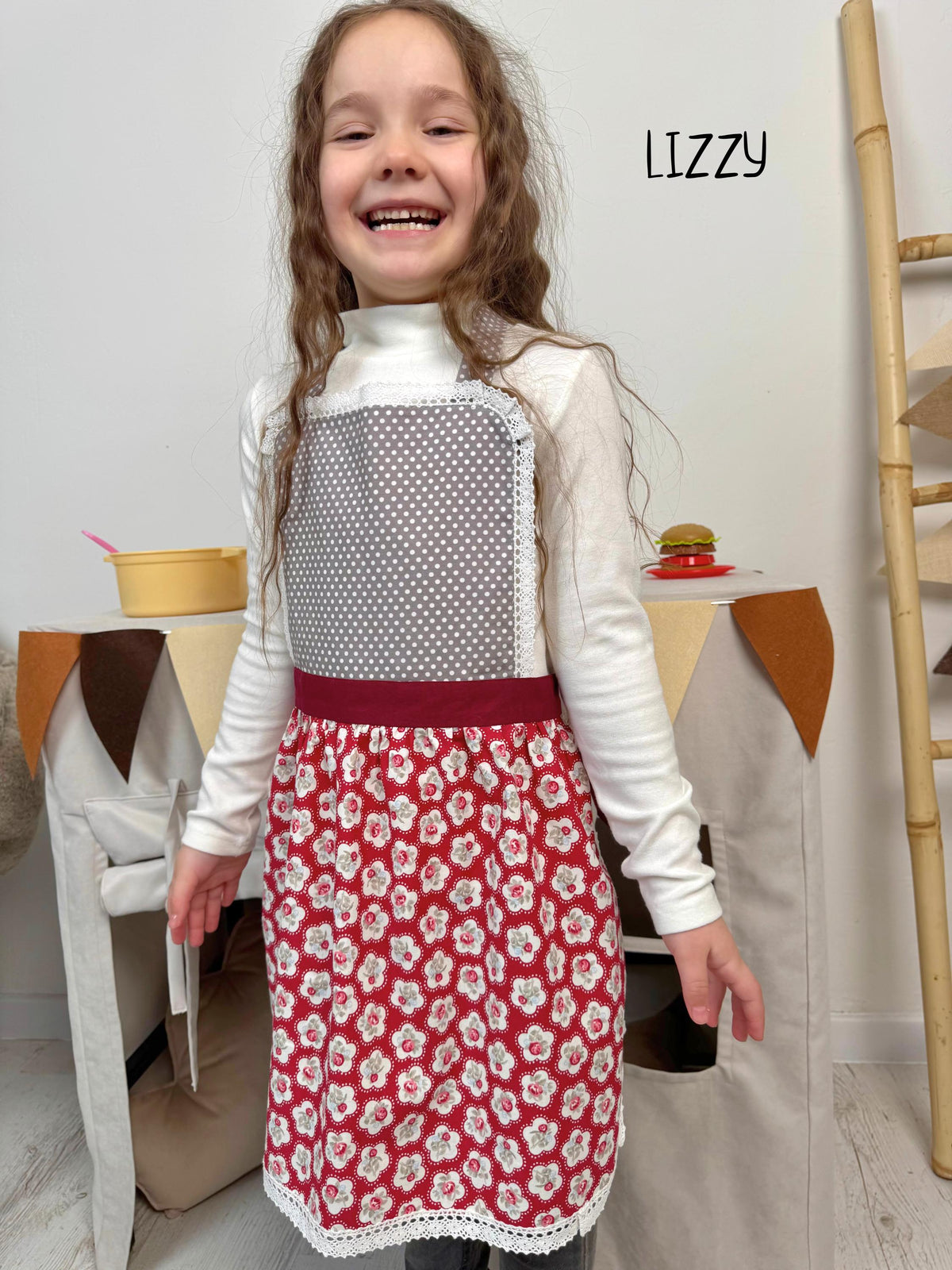 Burgundy lace apron on a child, full view