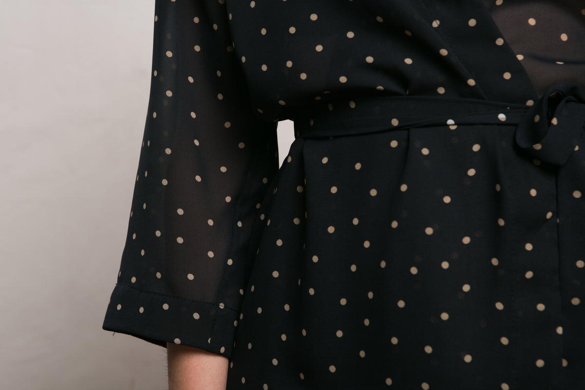 Close view of the beige polka dots on the black chiffon