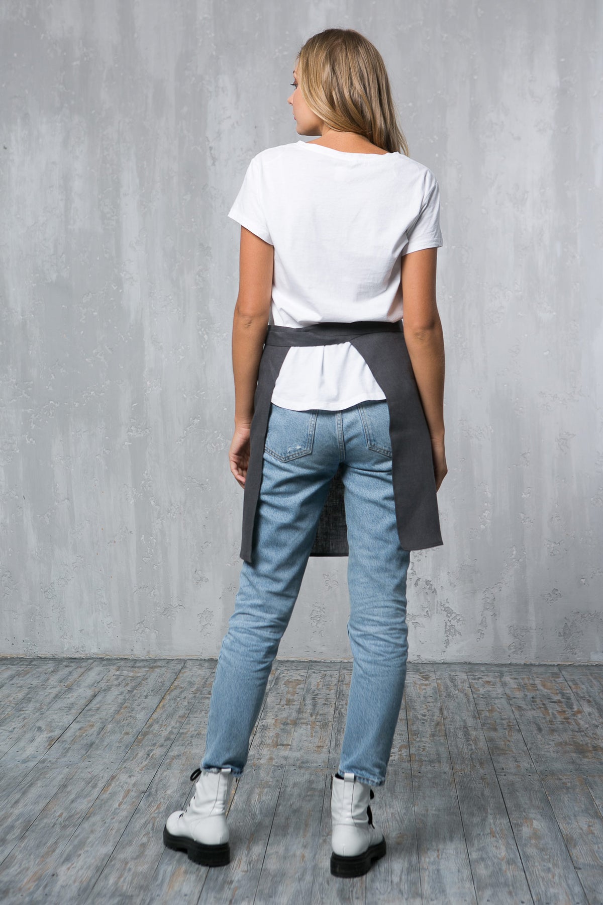 Grey linen waist apron worn by a barista