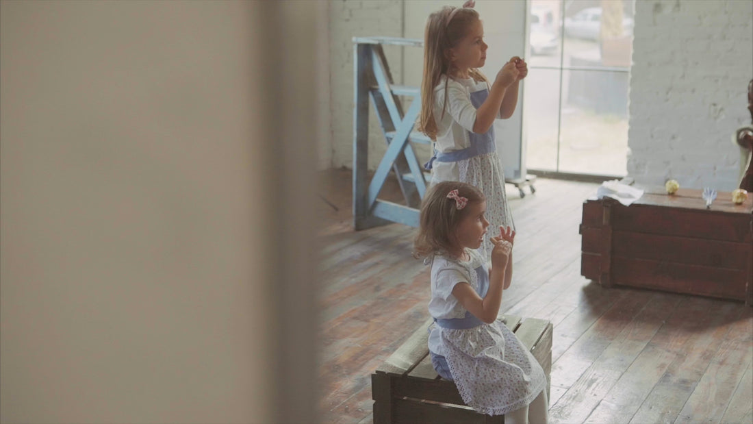 A 3 year old and a 5 year old girls wearing cute handmade kitchen aprons for kids while baking and crafting