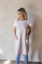Short linen crossback apron worn in a workshop